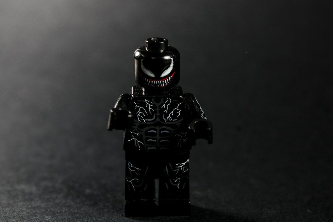 A black lego figure with white venom markings.