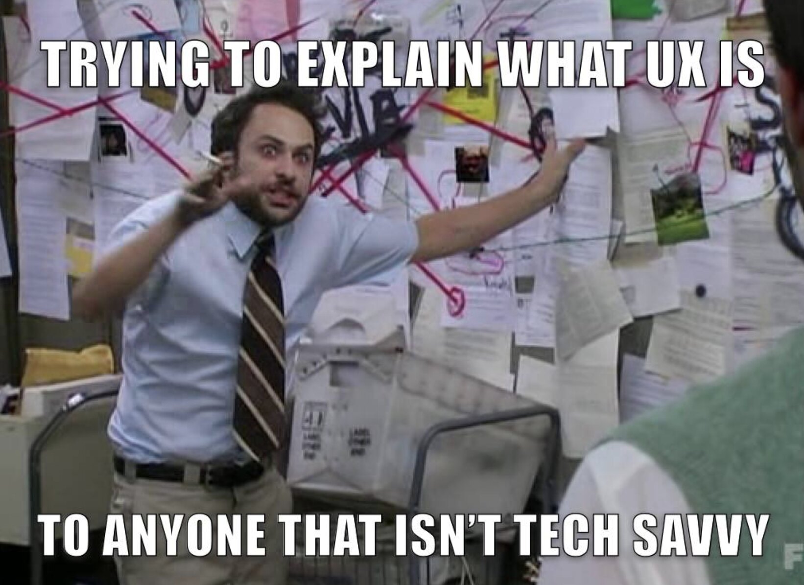 The conspiracy-board meme: a dishevelled man gesturing wildly in front of a wall of notes and red string, captioned Trying to explain what UX is to anyone that isn’t tech savvy.